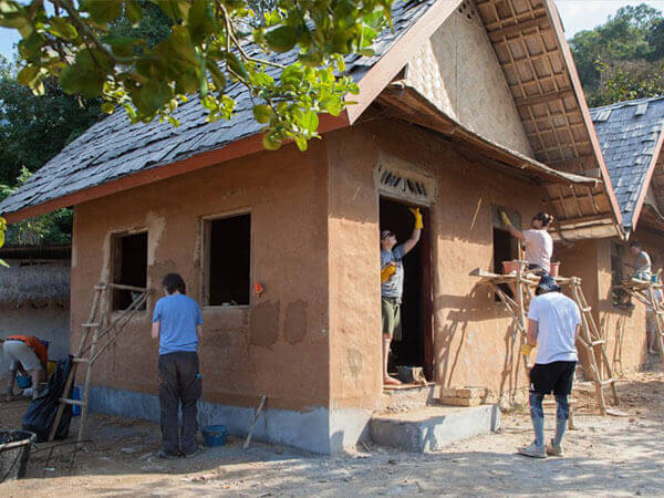 Workers repairing house with soil cement